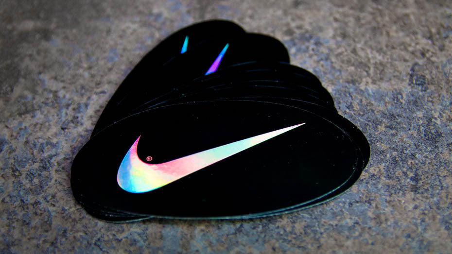 Stack of oval mirror silver sticker with nike logo on a table