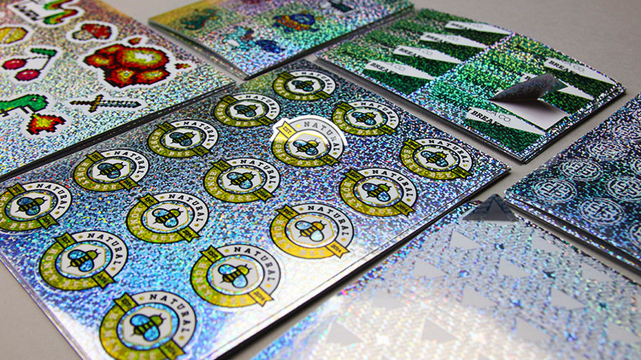 Stacks of glitter sheet waterproof labels on a table